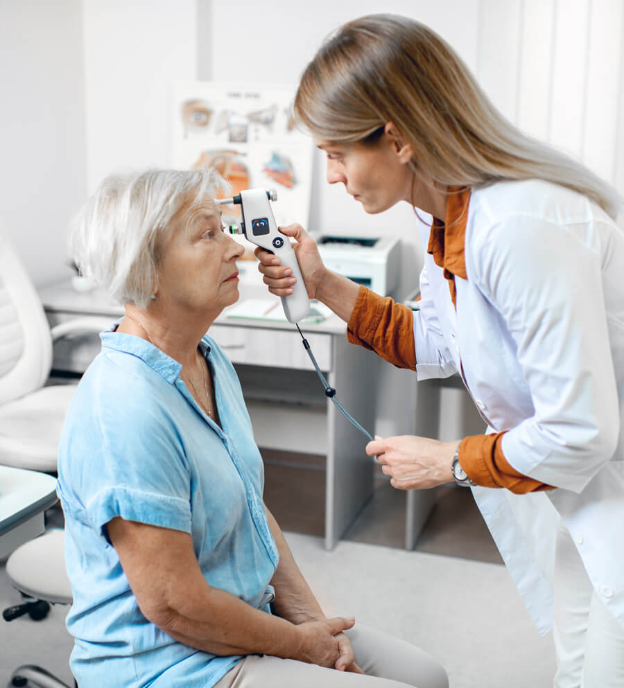 An eye doctor checking a woman's eyesight for diabetes related conditions