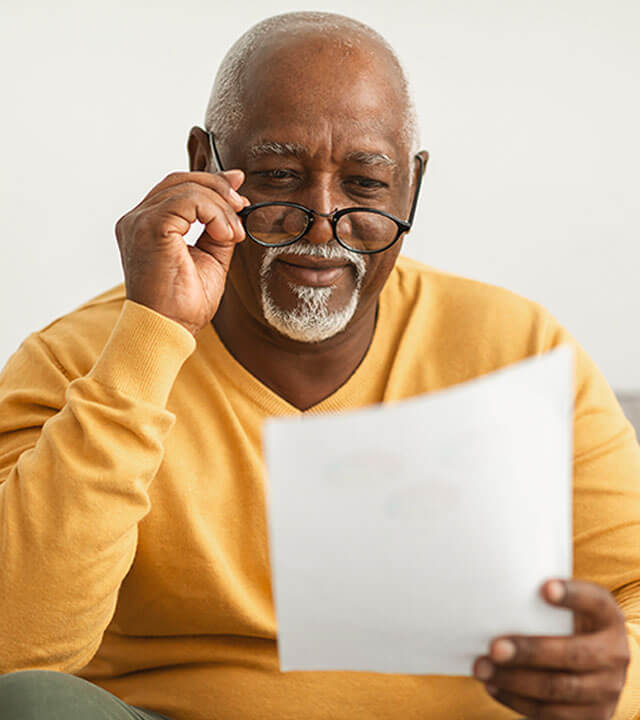 a man with aging eyes trying to read a paper