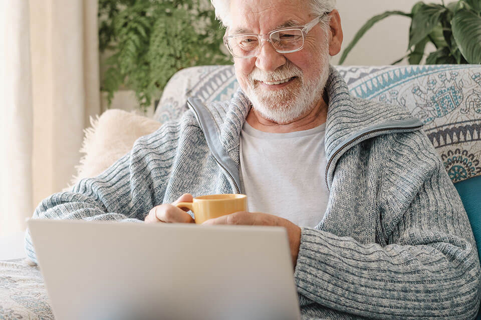 man with glasses reading testimonials on computer about Retina & Vitreous of Louisiana