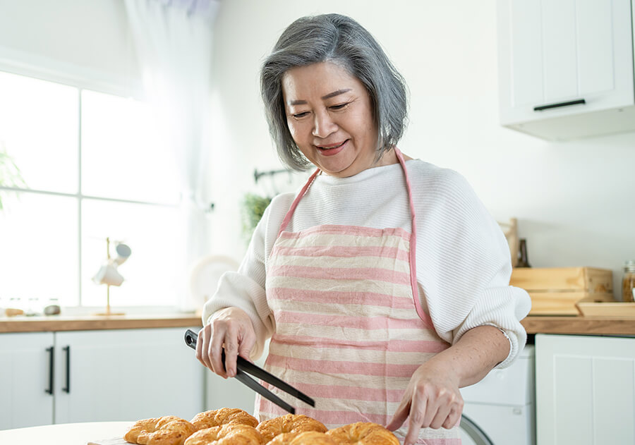 Elderly Asian woman baking enjoying her retina eye doctor care