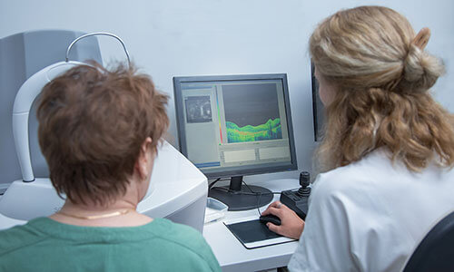 Retina specialist shows elderly woman data of test conducted on her eyes.