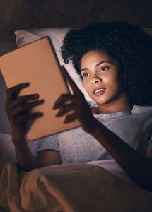 woman reading tablet in dark