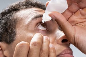 man applying eye drops for dry eyes retina problems